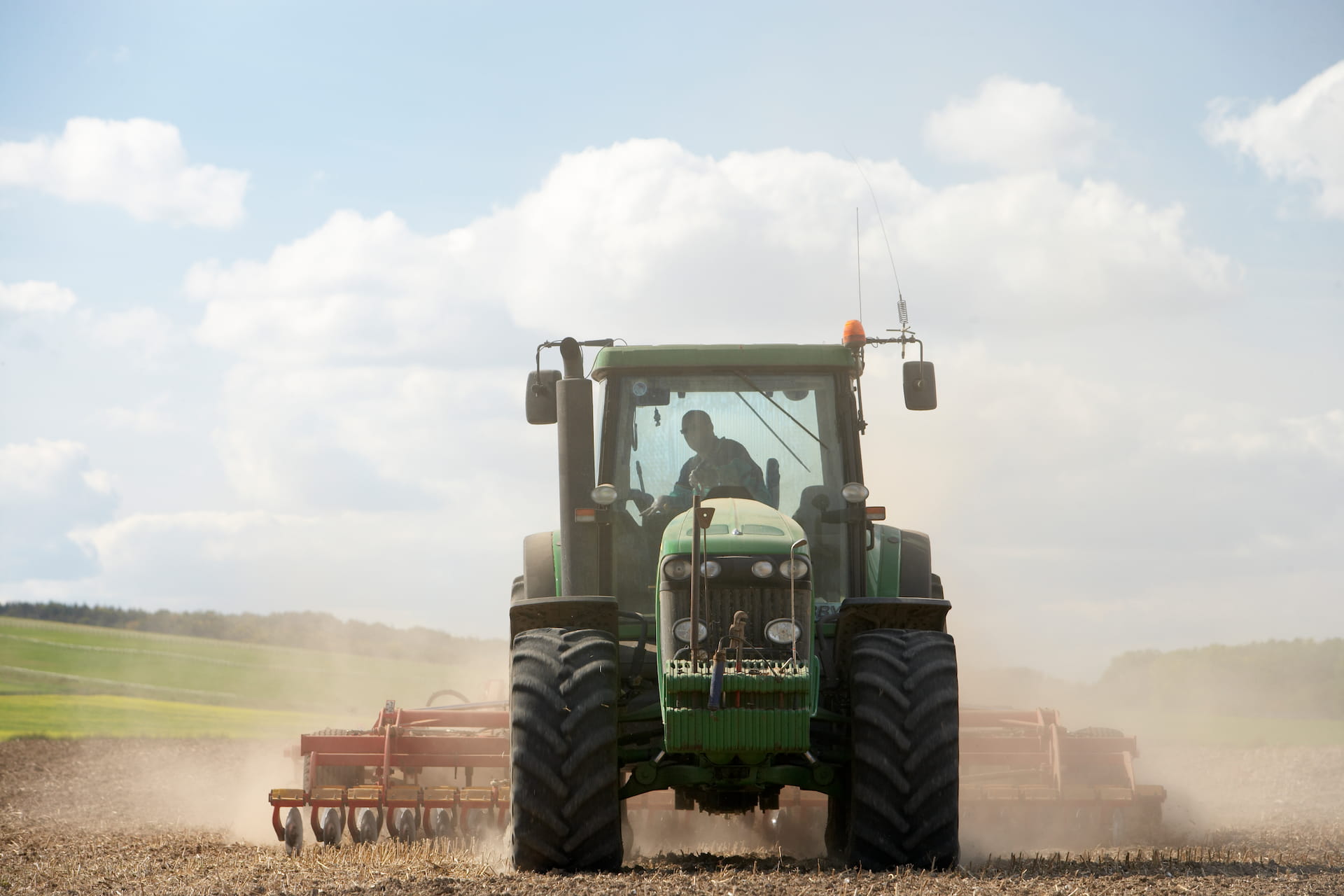 Traktor mit Grubber auf einem Feld